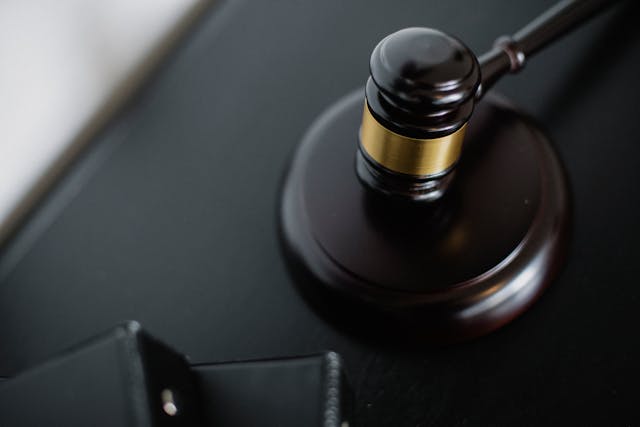A close-up of a judge’s gavel resting on a wooden sound block, symbolizing law and justice.