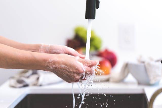 person-washing-hands-in-kitchen